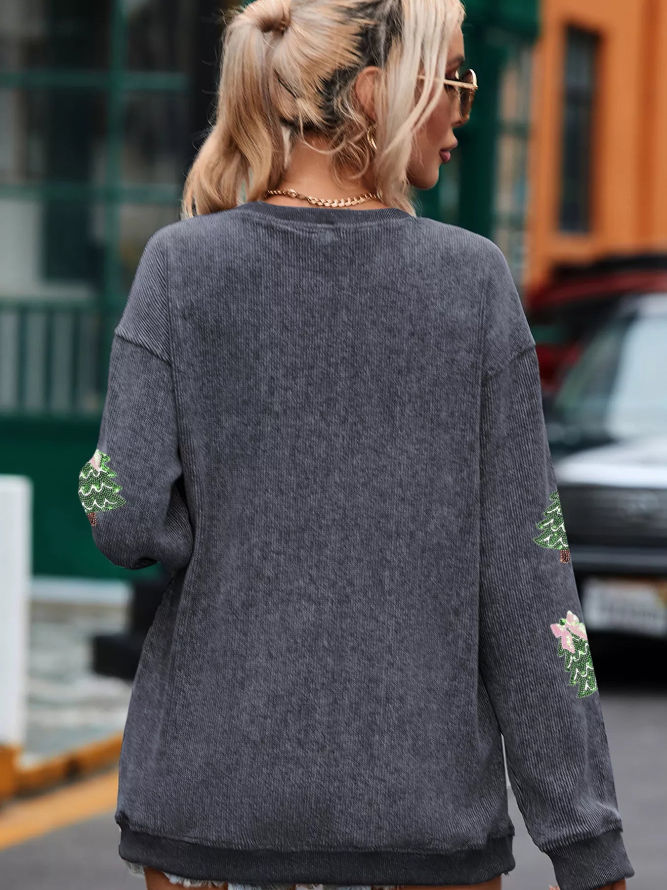 Back view of a woman wearing the Ribbed Round Neck Sequin Christmas Sweatshirt displaying festive details.