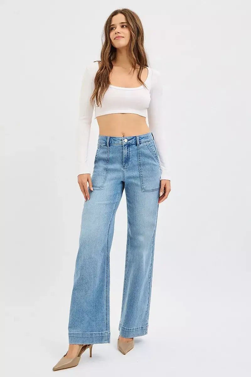 Model wearing RISEN Plus Size High Rise Straight Leg Jeans with front pockets and a cropped white top.