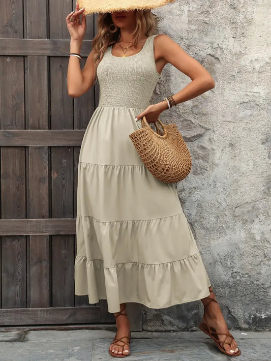 Ivy Lane Smocked Scoop Neck Sleeveless Tank Dress in beige, featuring a tiered skirt and stylish sun hat.