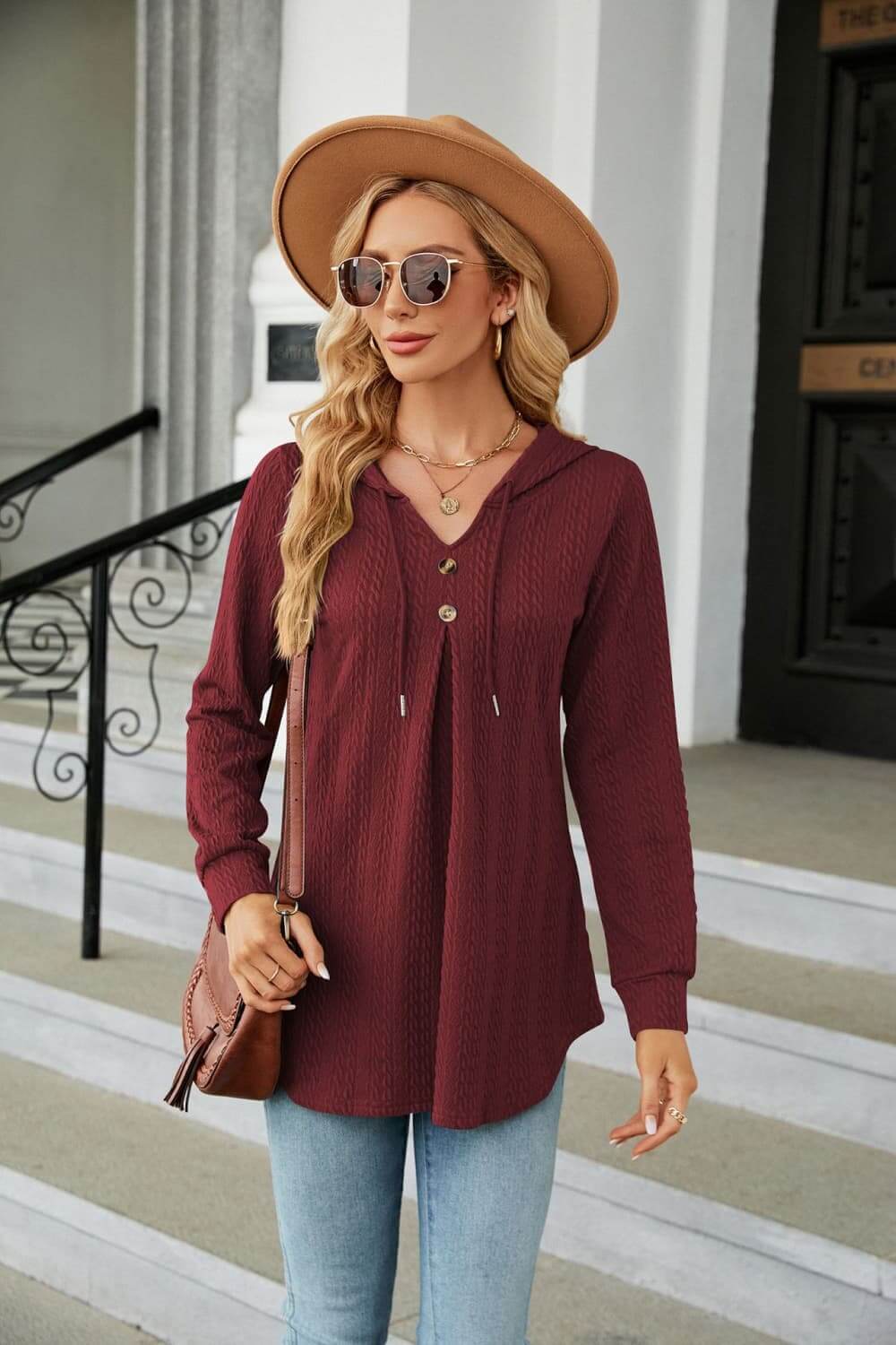 Long Sleeve Hooded Blouse in burgundy worn with sunglasses and a hat, perfect for casual outfits.