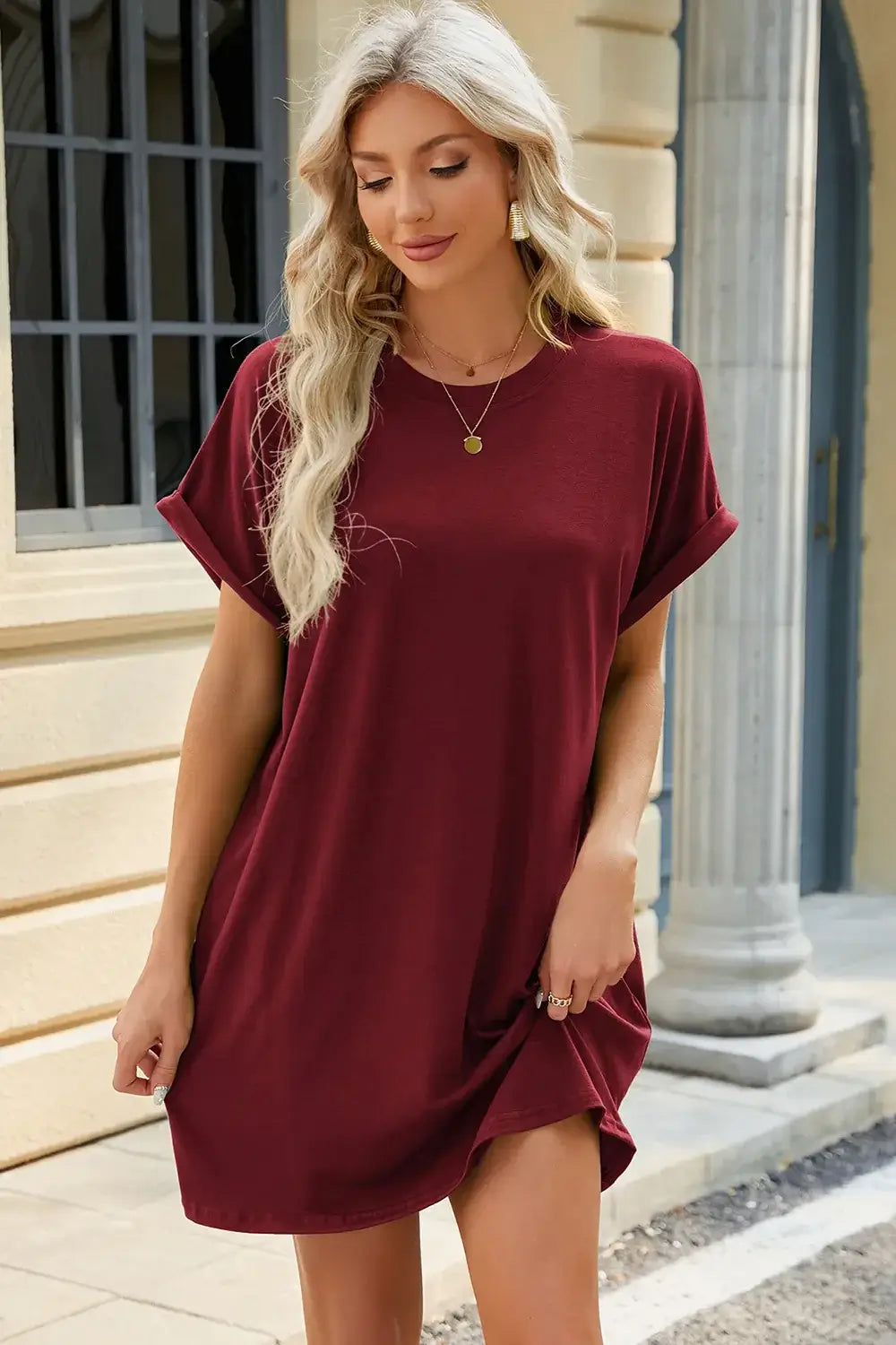Model wearing a burgundy Round Neck Rolled Short Sleeve Tee Dress, styled casually in an outdoor setting.
