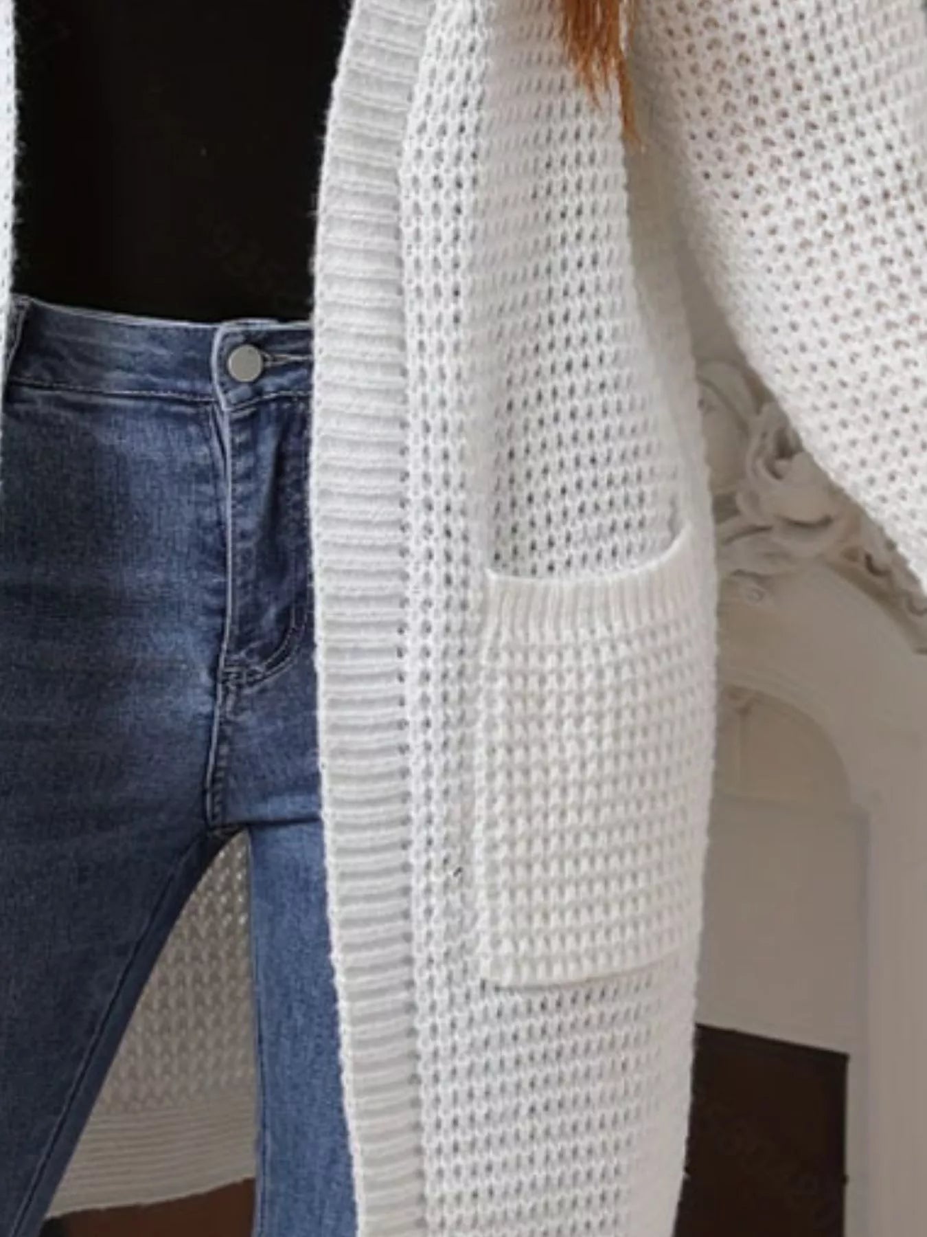 Chunky Knit Open Front Cardigan in white, layered over jeans, showcasing its cozy design and pockets.