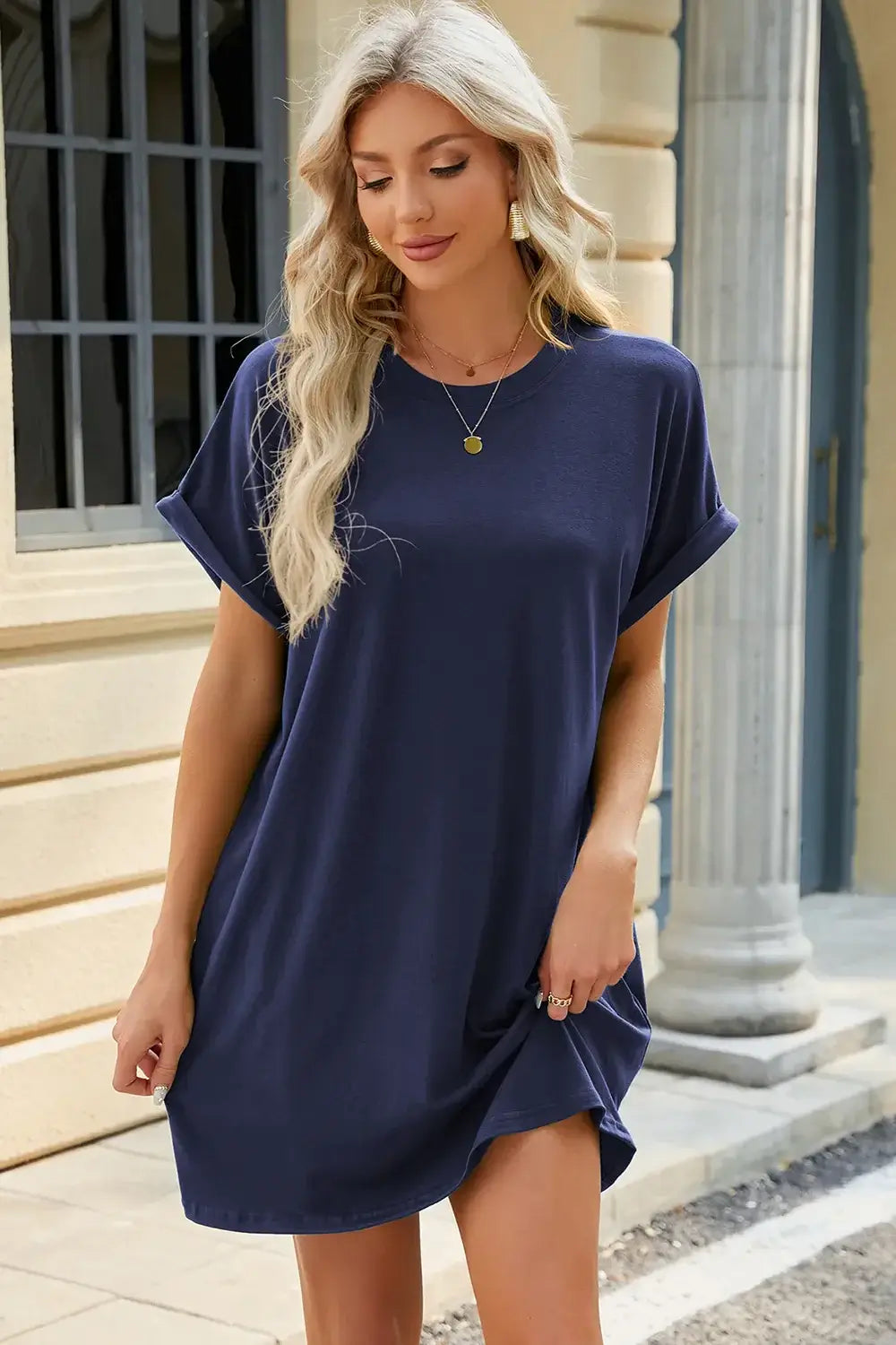 Woman wearing a navy Round Neck Rolled Short Sleeve Tee Dress, featuring relaxed style and rolled sleeves.