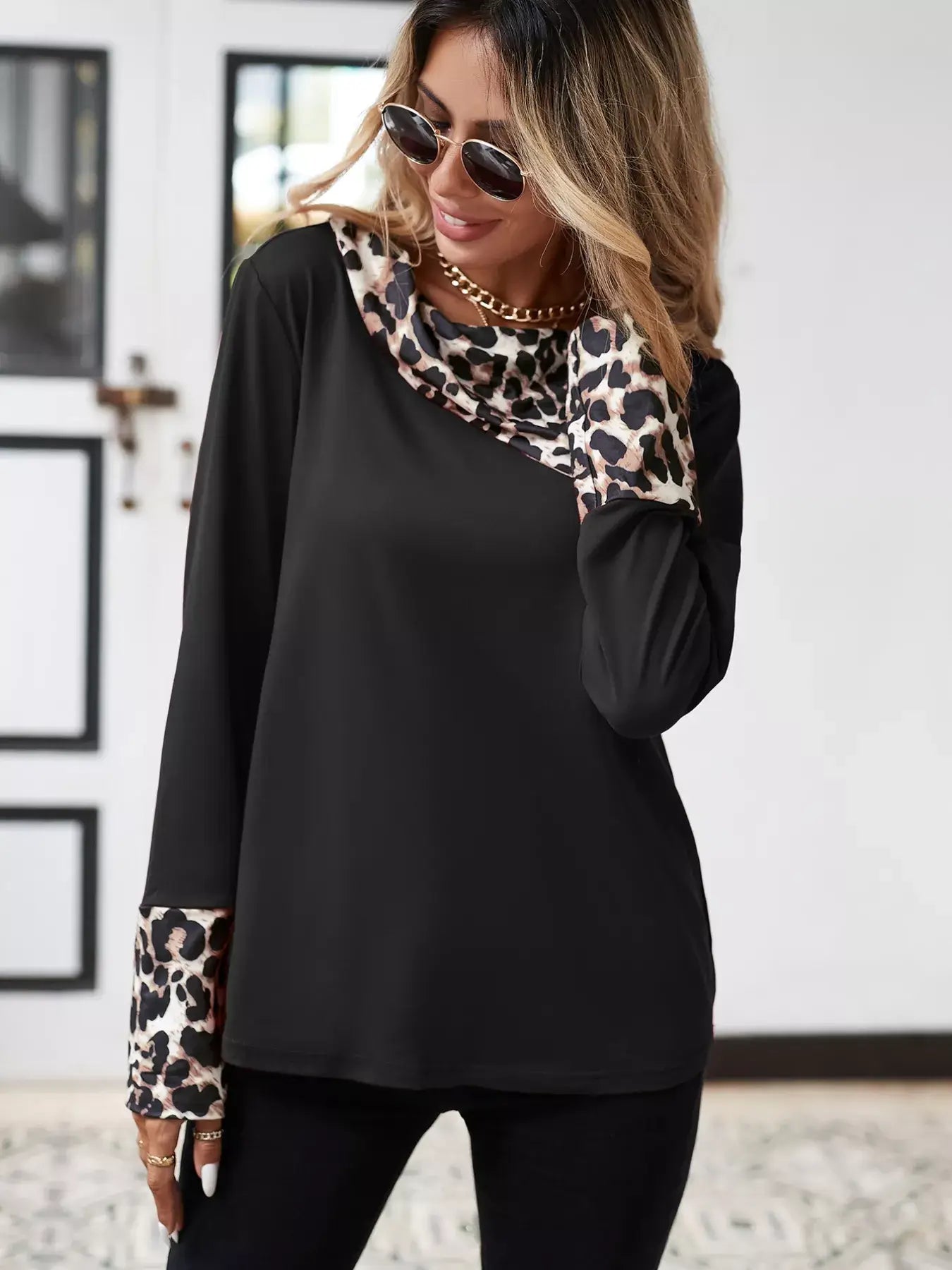 Woman wearing a leopard long sleeve blouse with stylish print accents, perfect for casual or office wear.