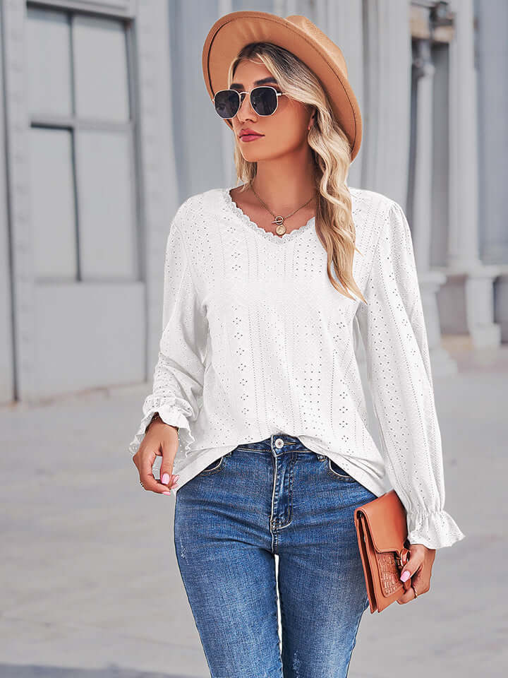 Model wearing Eyelet V-Neck Flounce Sleeve Blouse in white paired with jeans and a hat, showcasing feminine style.