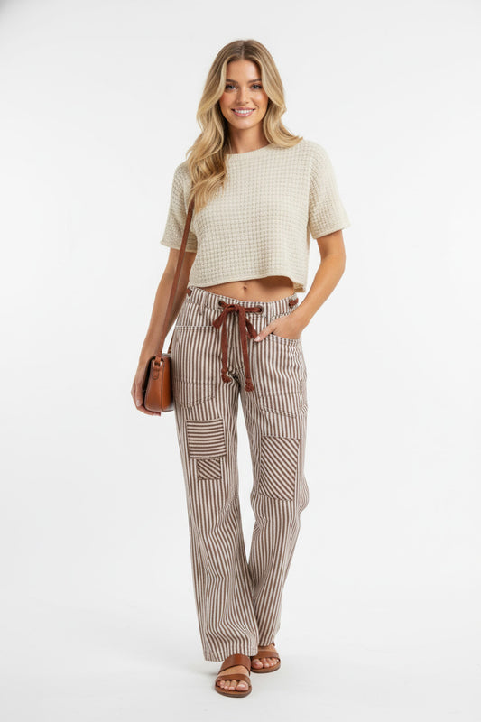 Woman wearing Drawstring Striped Twill Barrel Pants with a cozy top and holding a bag, showcasing a chic and relaxed style.
