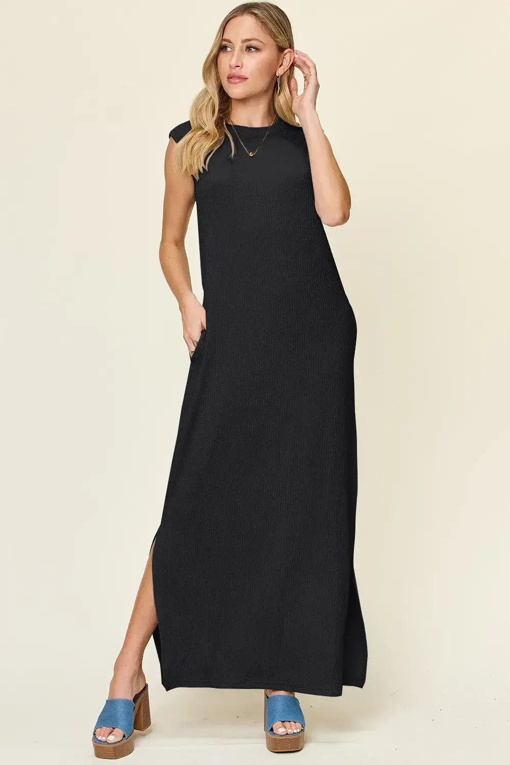 Black sleeveless maxi dress with mock neck and side pockets, perfect for casual wear.