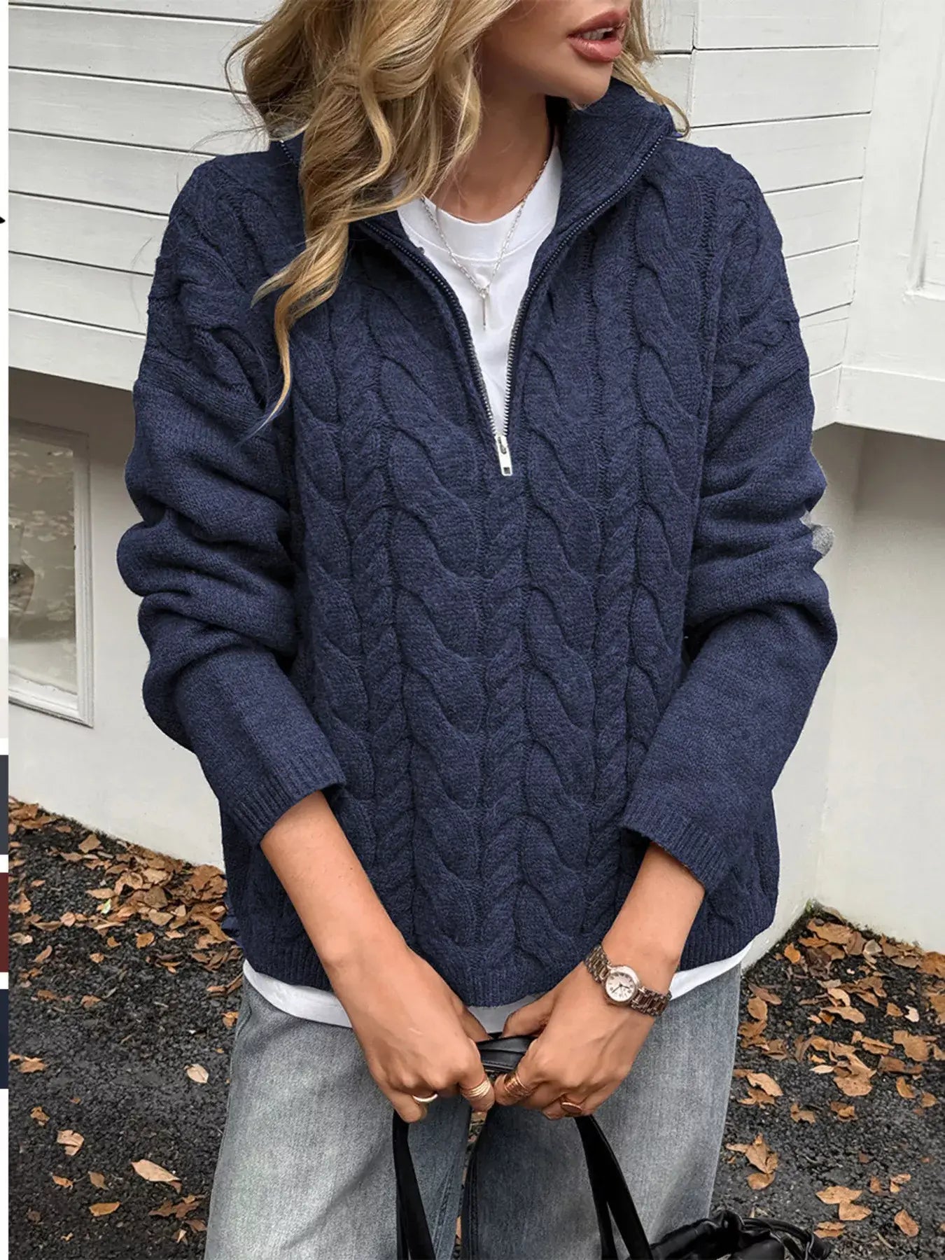 Woman wearing a zip collar cable-knit sweater in navy, showcasing its cozy style and zip-up functionality.