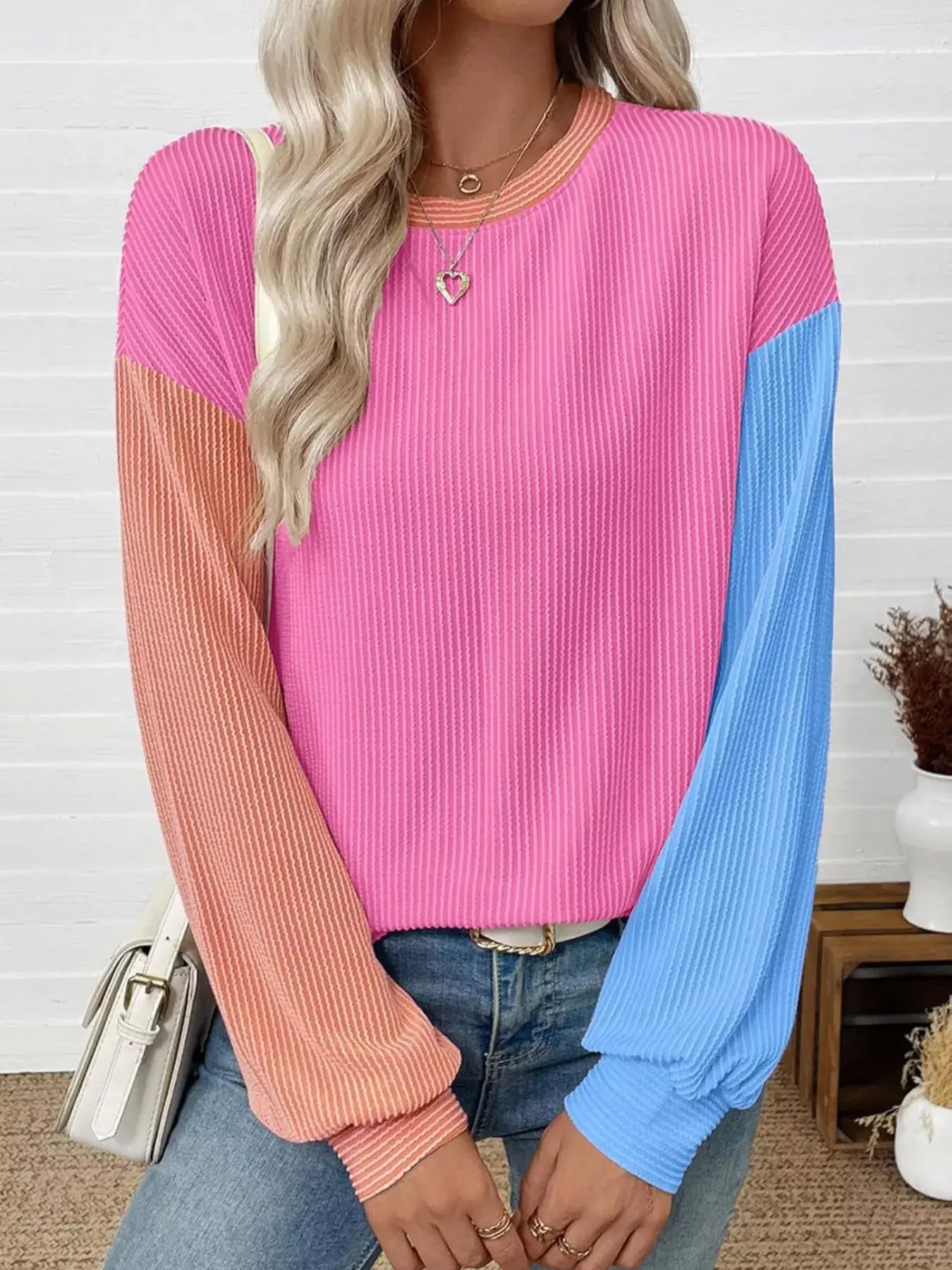 Model wearing a colorful Color Block Ribbed Long Sleeve T-Shirt in pink and blue, styled for a casual chic look.