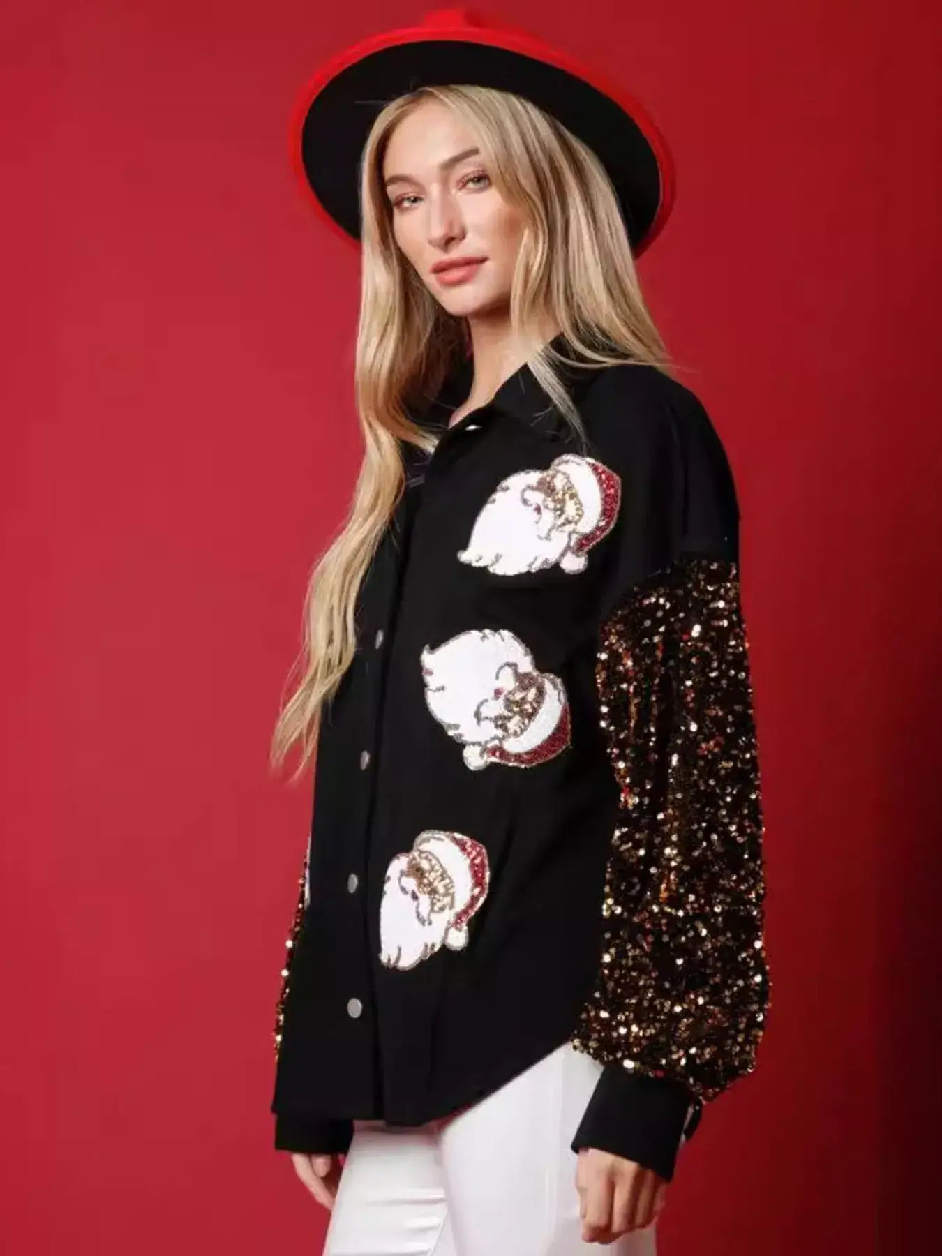 Model wearing a christmas santa sequin long sleeve shirt with playful Santa graphics and sequin sleeves on a festive red background.
