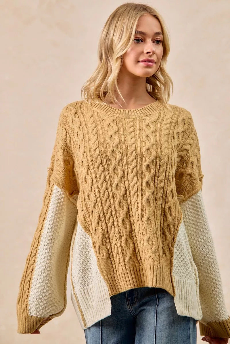 BiBi Cable Knit Hacci Combo Sweater with uneven hem, showcasing a cozy and stylish design.