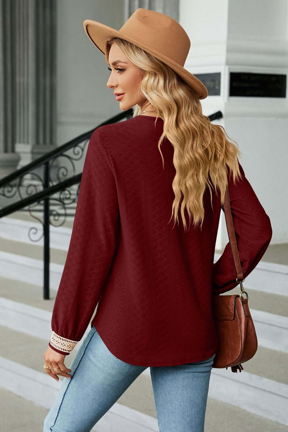 V-Neck Long Sleeve Blouse in burgundy worn with a hat, showcasing elegant style and casual comfort.