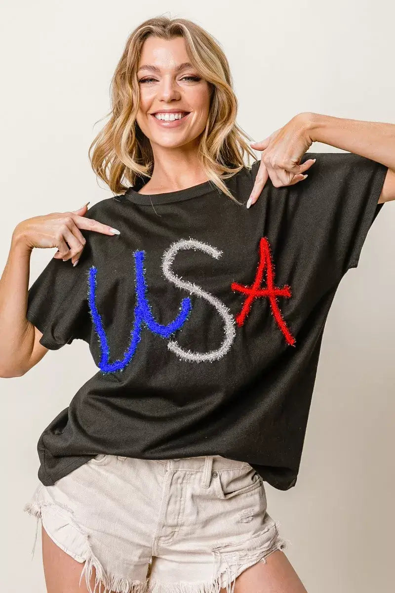 BiBi metallic letter short dolman sleeve top featuring 'USA' in red, white, and blue rhinestones for a chic, relaxed style.