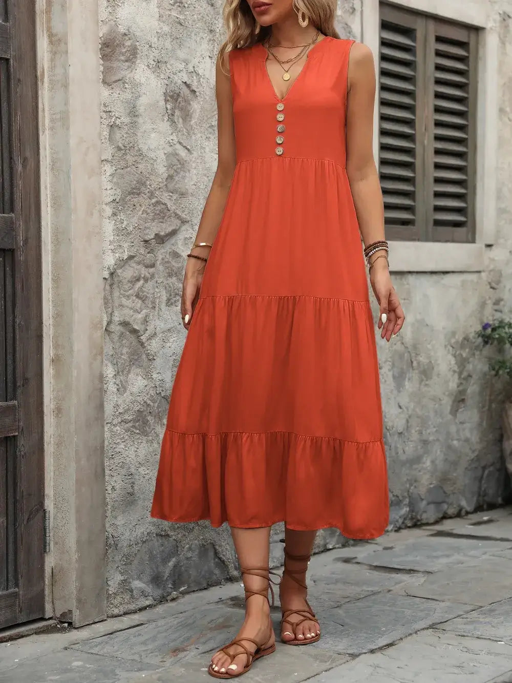 Ivy Lane Decorative Button Notched Sleeveless Dress in a vibrant orange color, featuring decorative buttons and a tiered skirt.