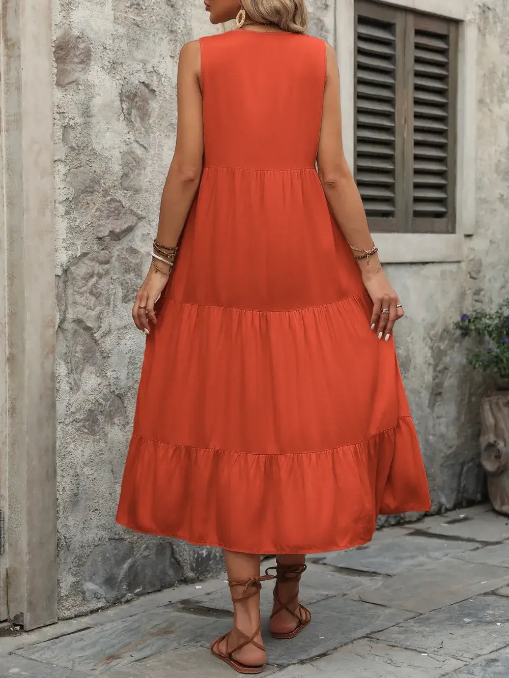 Ivy Lane Decorative Button Notched Sleeveless Dress shown in a beautiful orange color, highlighting its tiered design and casual style.