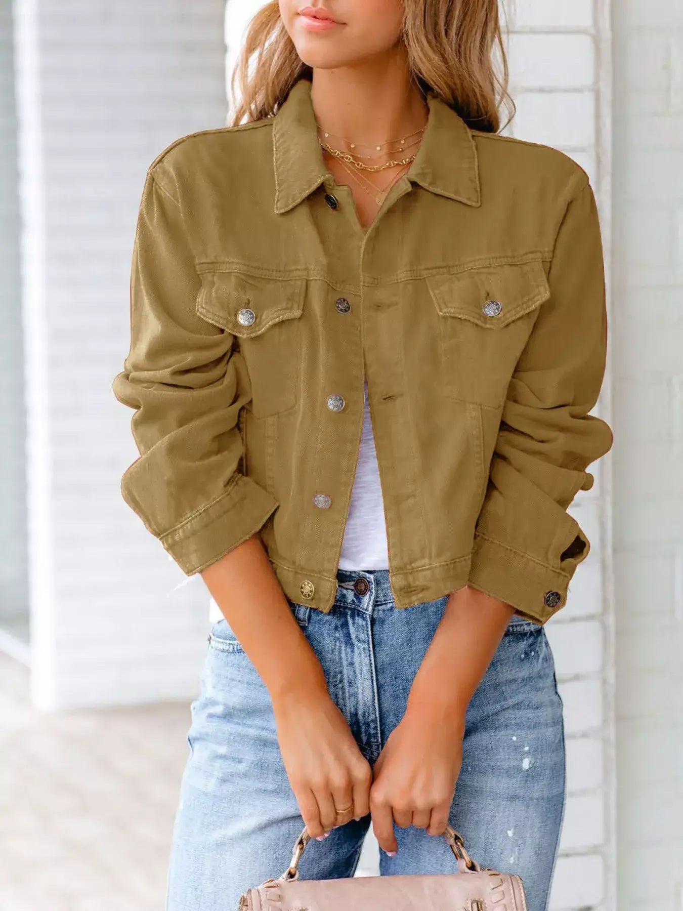Women wearing a stylish button-up long sleeve denim jacket in khaki, paired with casual jeans and a white top.