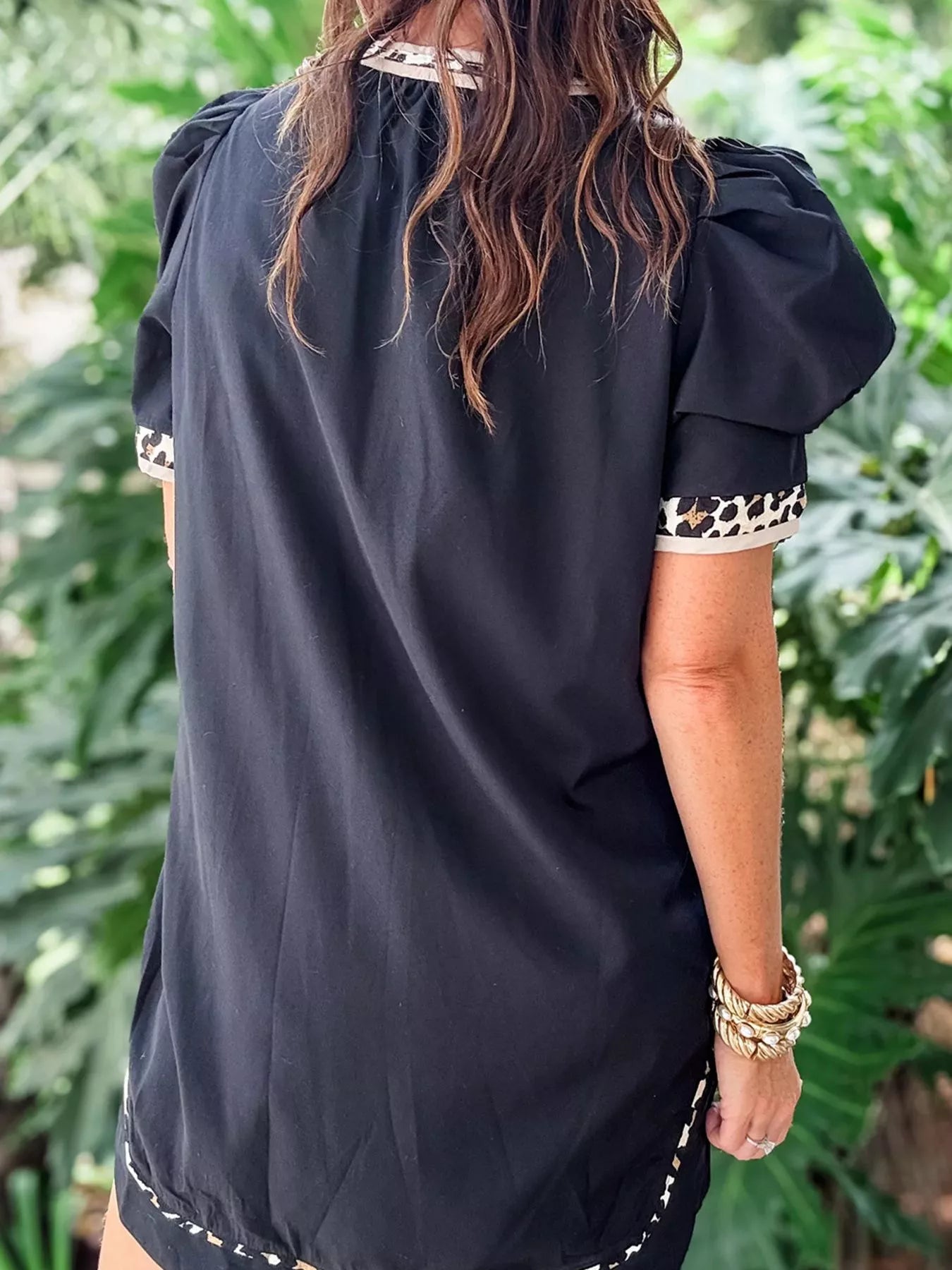 Back view of a Notched Puff Sleeve Mini Dress highlighting puff sleeves and stylish animal print trim.