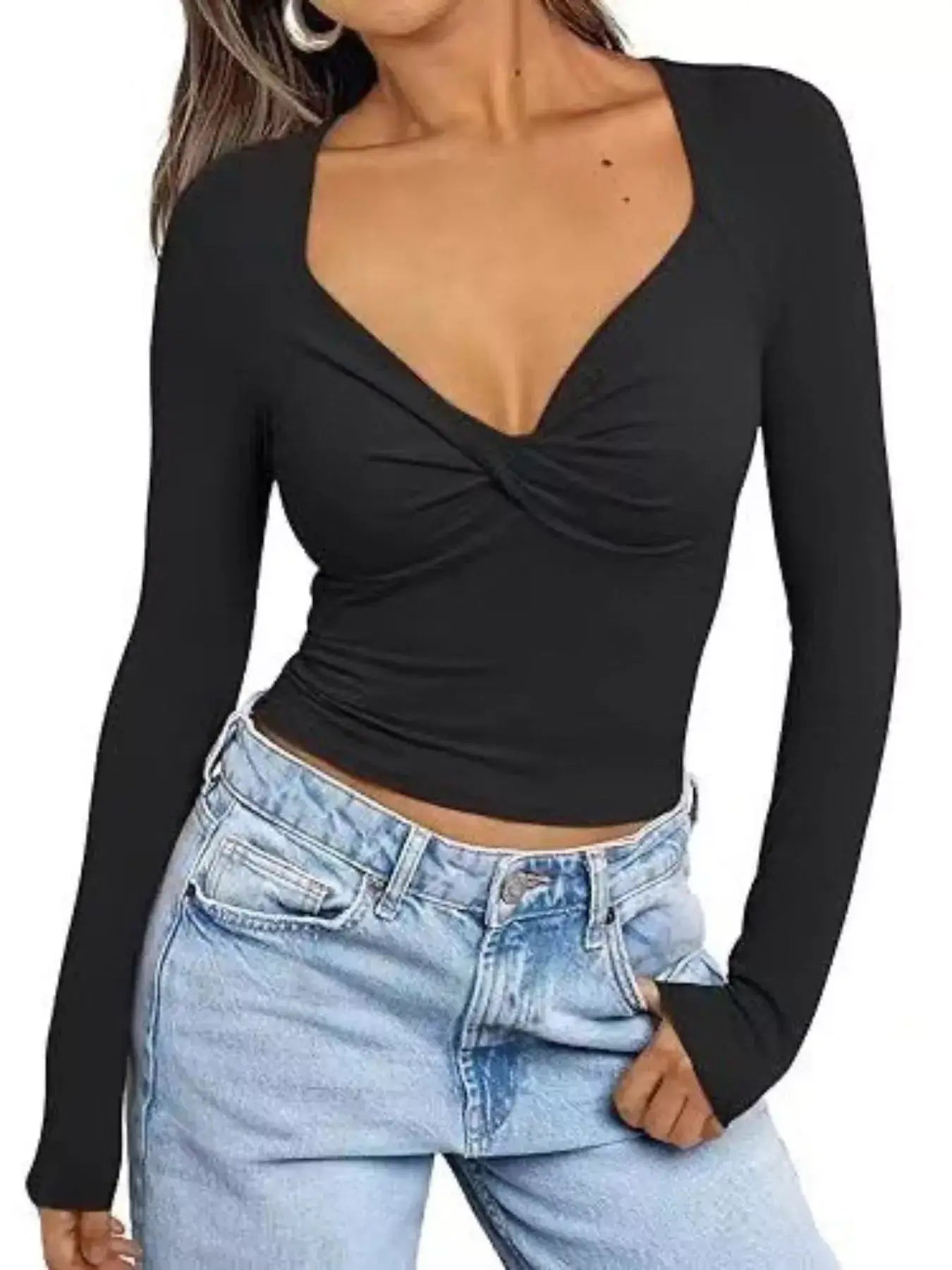 Woman wearing a black twist front long sleeve fitted t-shirt paired with light blue jeans.