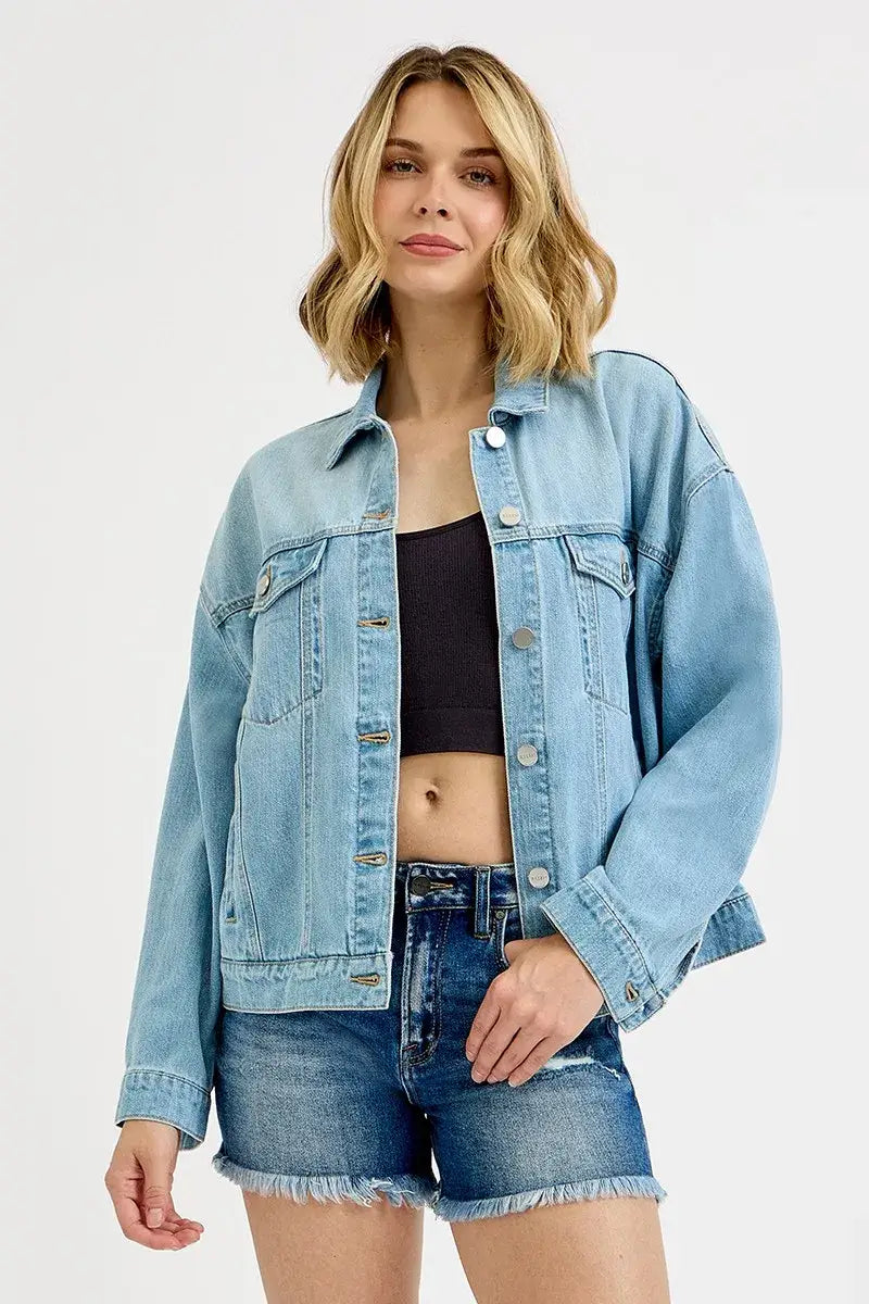 Model wearing RISEN Washed Dropped Shoulder Denim Jacket in light blue, styled with a black top and denim shorts.