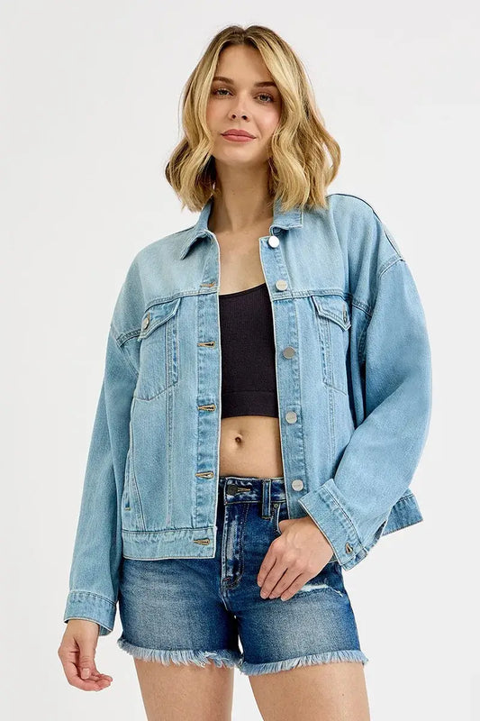 Model wearing RISEN Washed Dropped Shoulder Denim Jacket with light-blue finish over a black crop top and denim shorts.