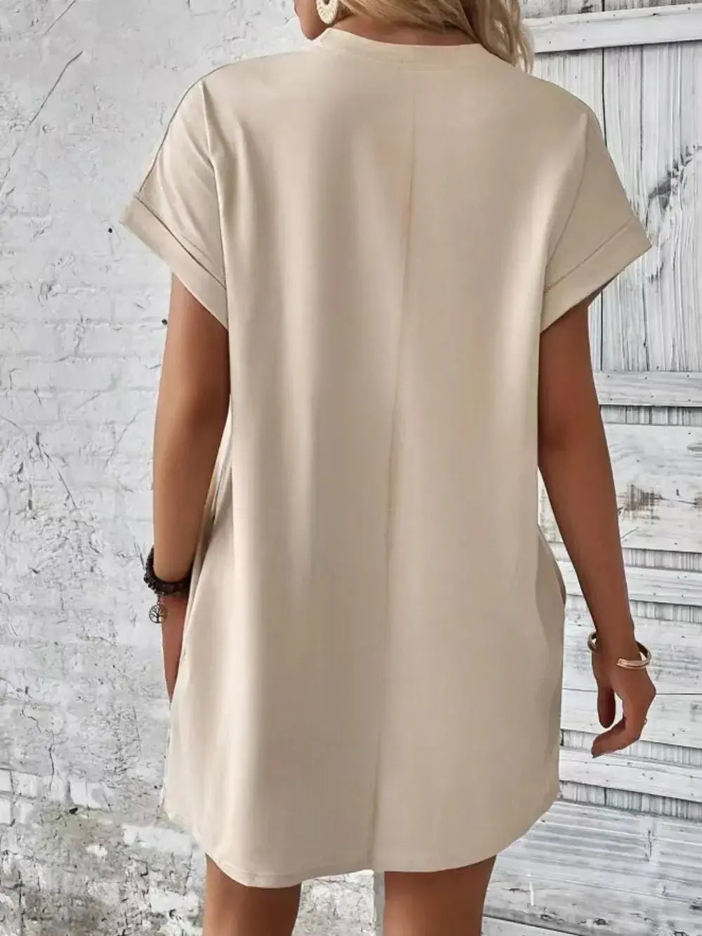 Back view of a pocketed round neck short sleeve dress in beige, showcasing casual style and comfortable fit.