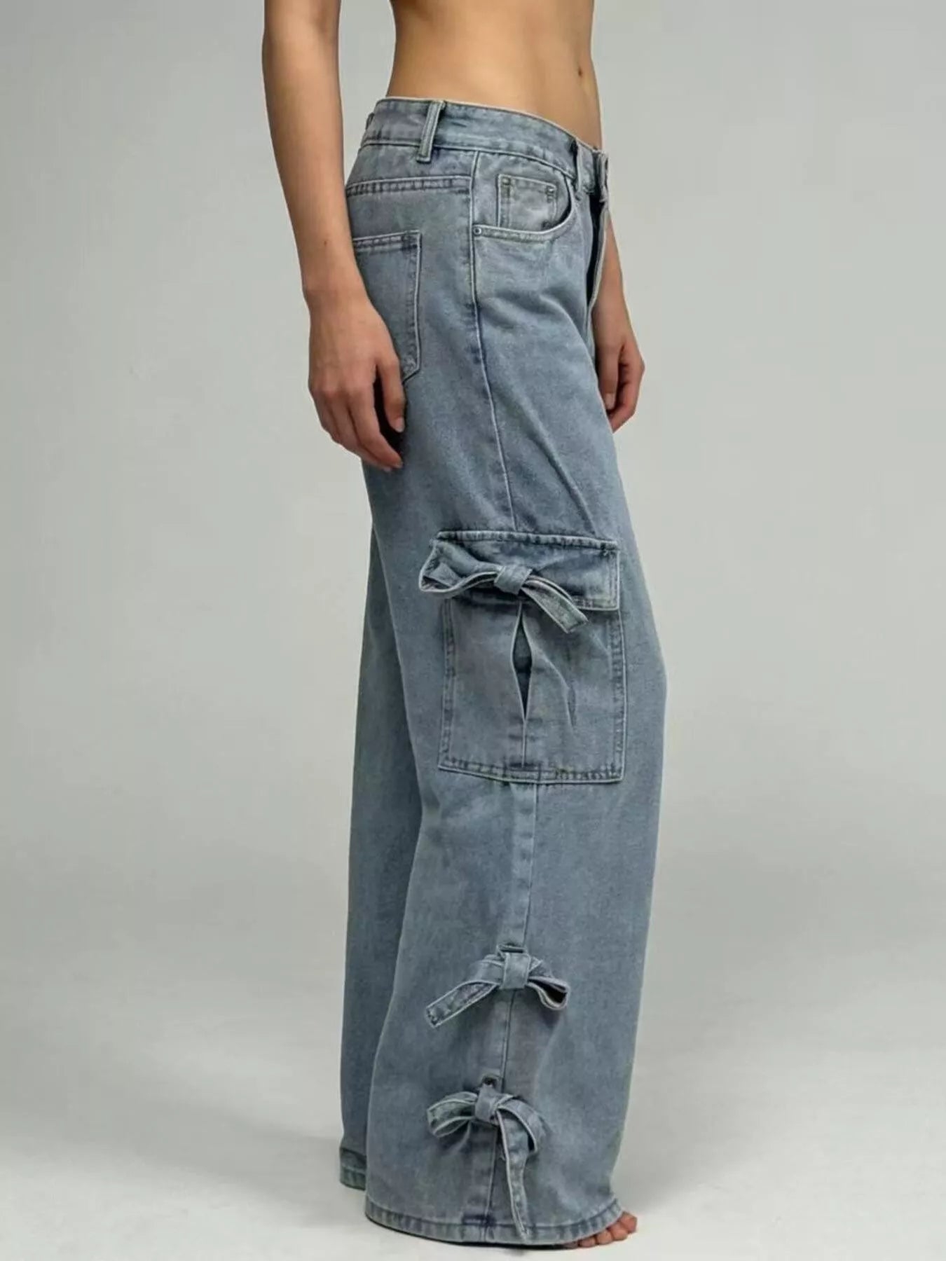 Side view of Bow Wide Leg Jeans with Pocketed Detail and Relaxed Fit, featuring stylish bow accents.