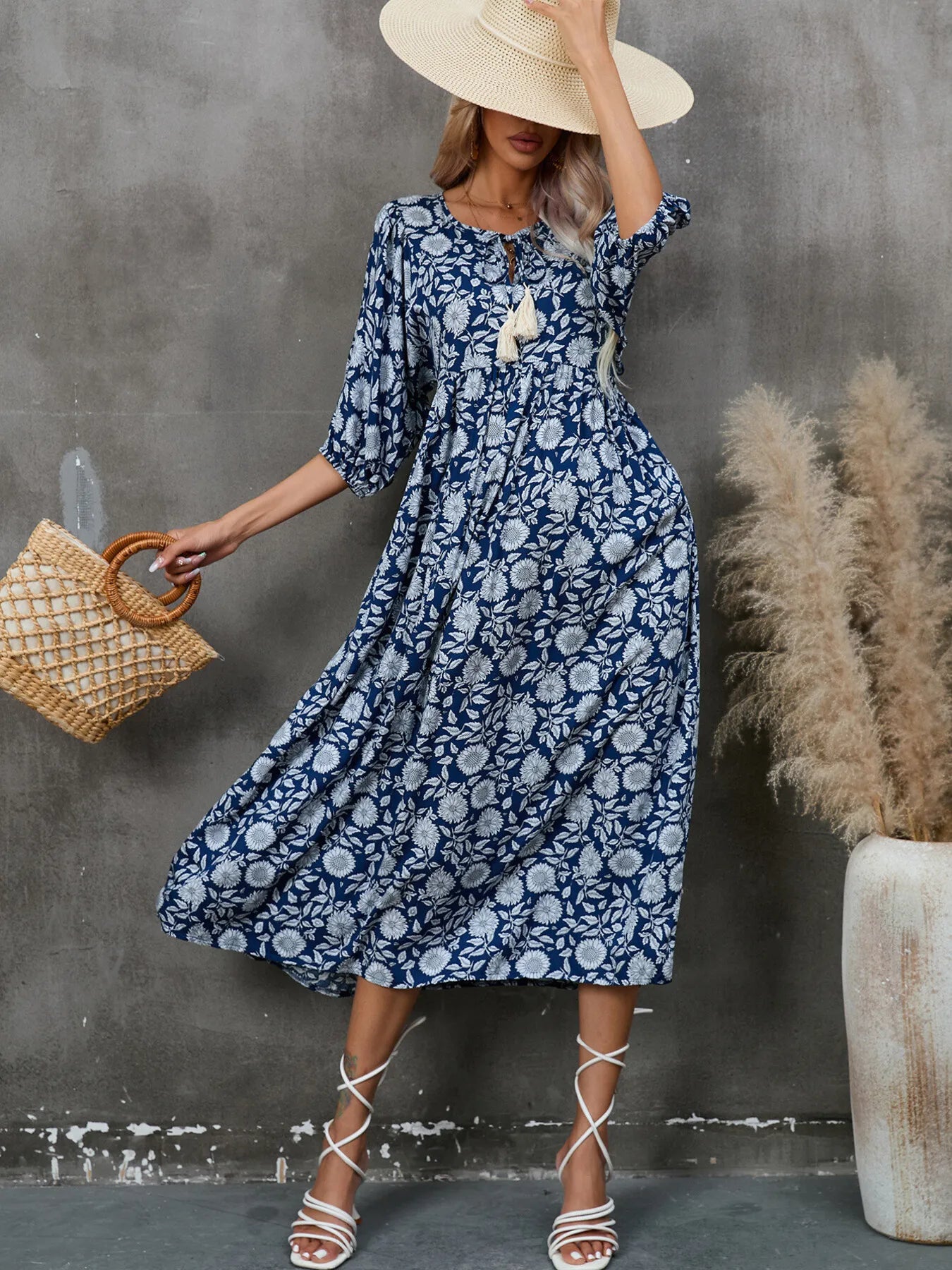 Printed Tie Neck Midi Dress featuring a ruched design and tassel detail in a floral print with a stylish hat.