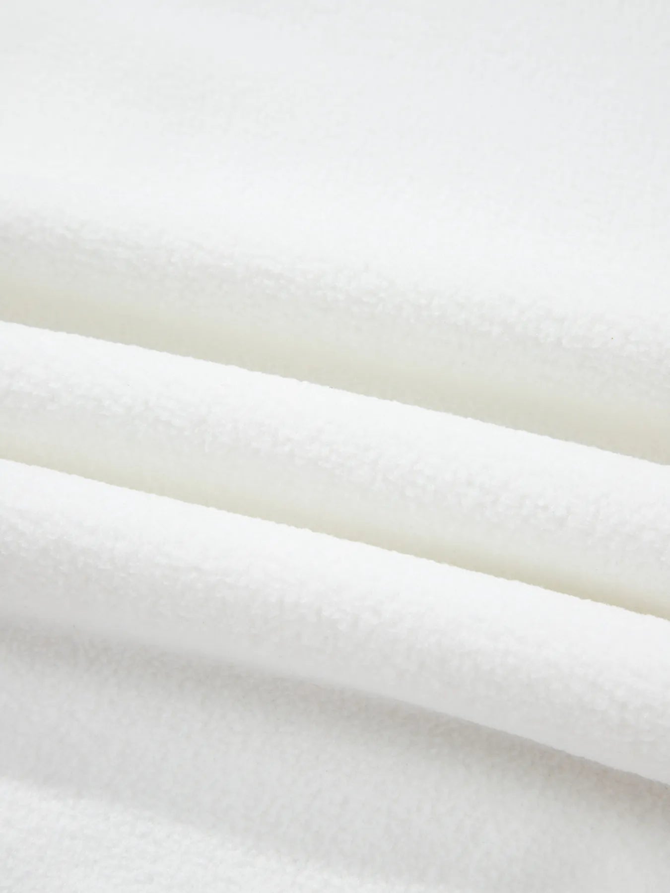 Close-up of soft white fabric texture used in Exposed Seam Chest Pocket Knit Pullover Sweatshirt.