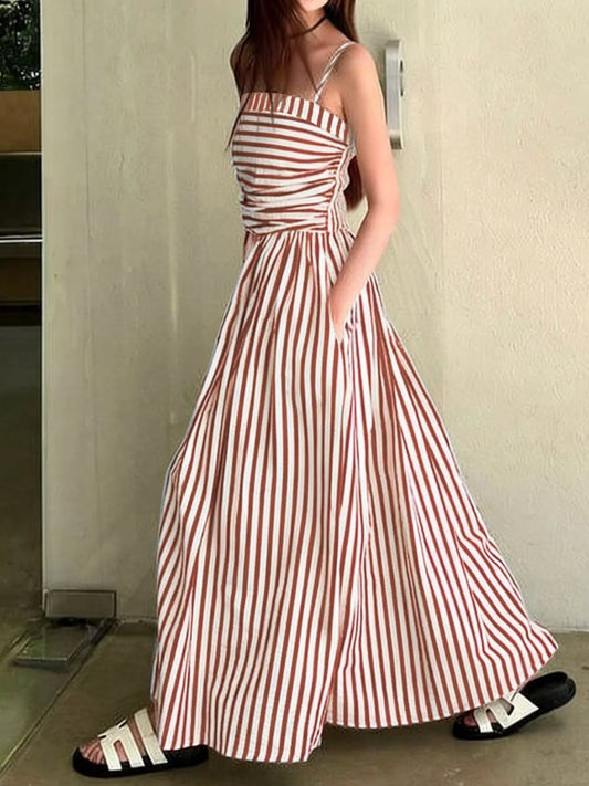 Model wearing a Striped Spaghetti Strap Casual Maxi Dress showcasing pockets and a flowing design.