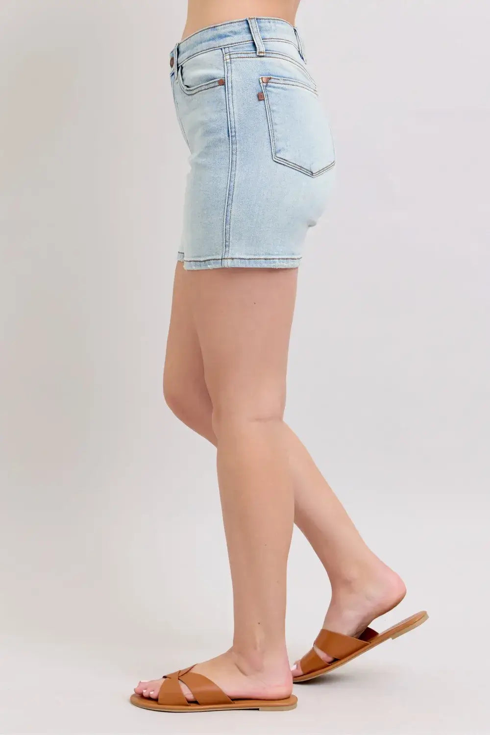 Plus size Judy Blue denim shorts with 2-button closure and pockets, styled with tan sandals.