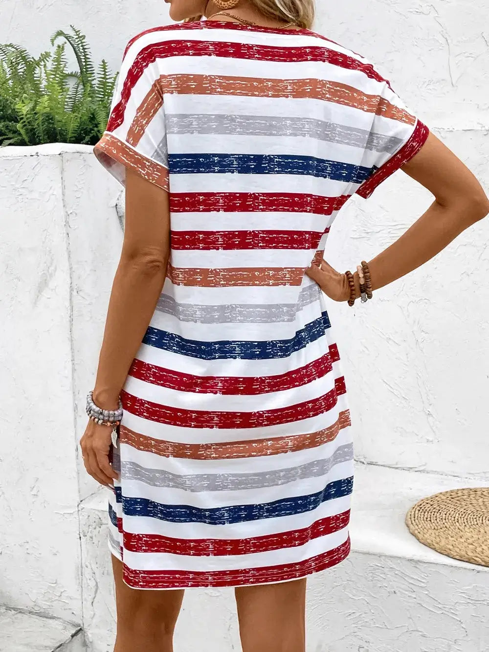 Back view of a striped V-neck short sleeve dress featuring red, blue, and white stripes, perfect for casual outings.