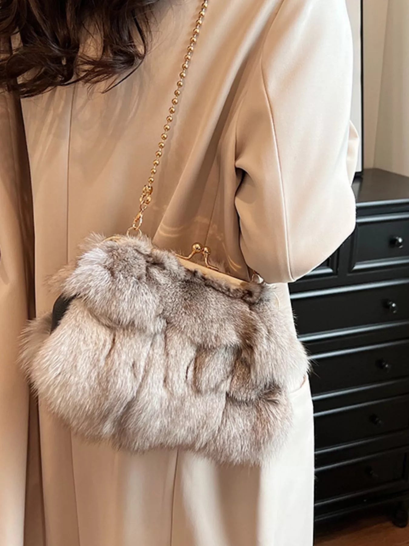 Furry Chain Crossbody Bag displayed on a person wearing a beige coat, showcasing its stylish fox fur material.