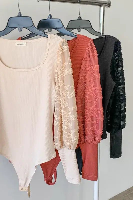 Textured puff sleeve bodysuit collection showcasing different colors and elegant lace details on the sleeves.