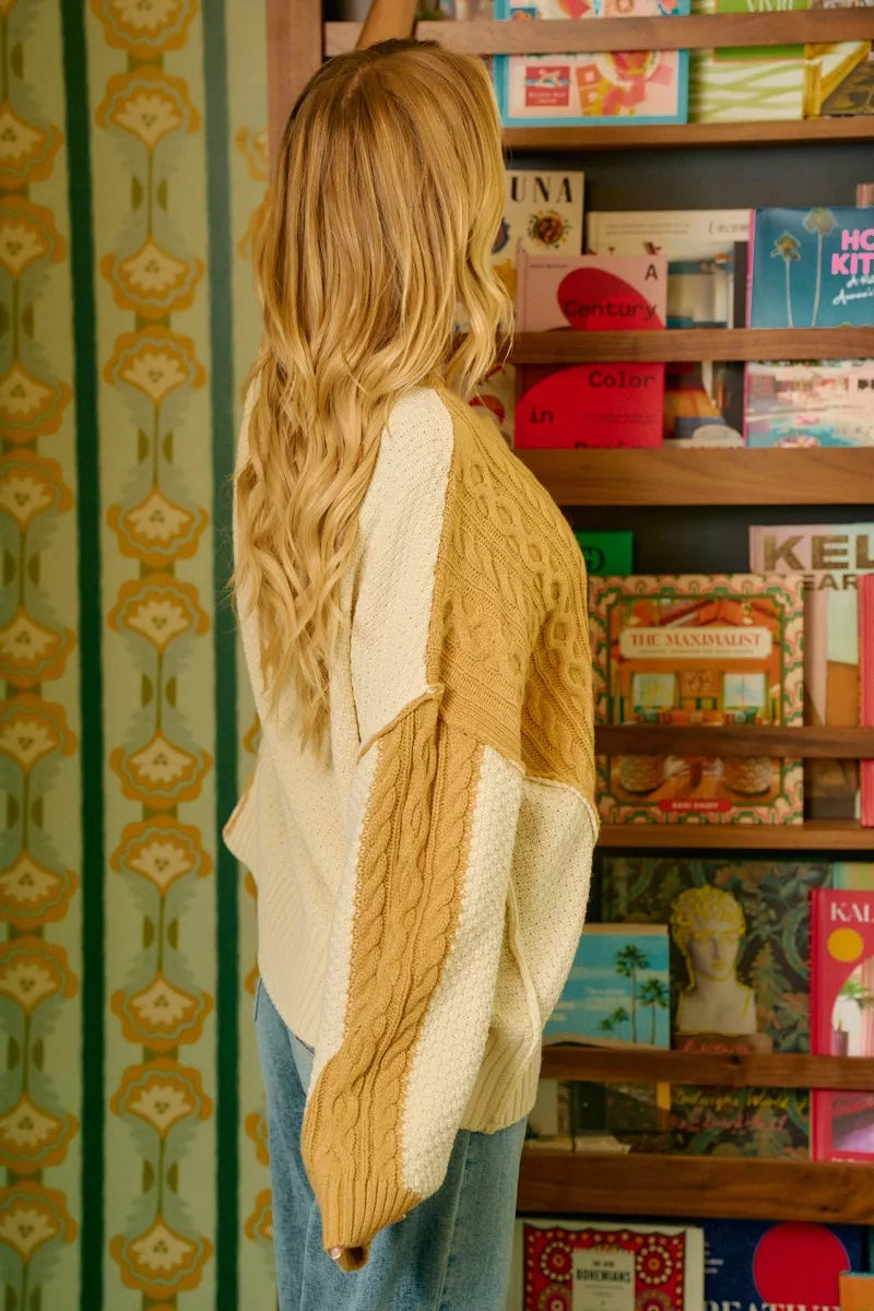 BiBi Cable Knit Hacci Combo Sweater with uneven hem, featuring a cozy design and classic textures.