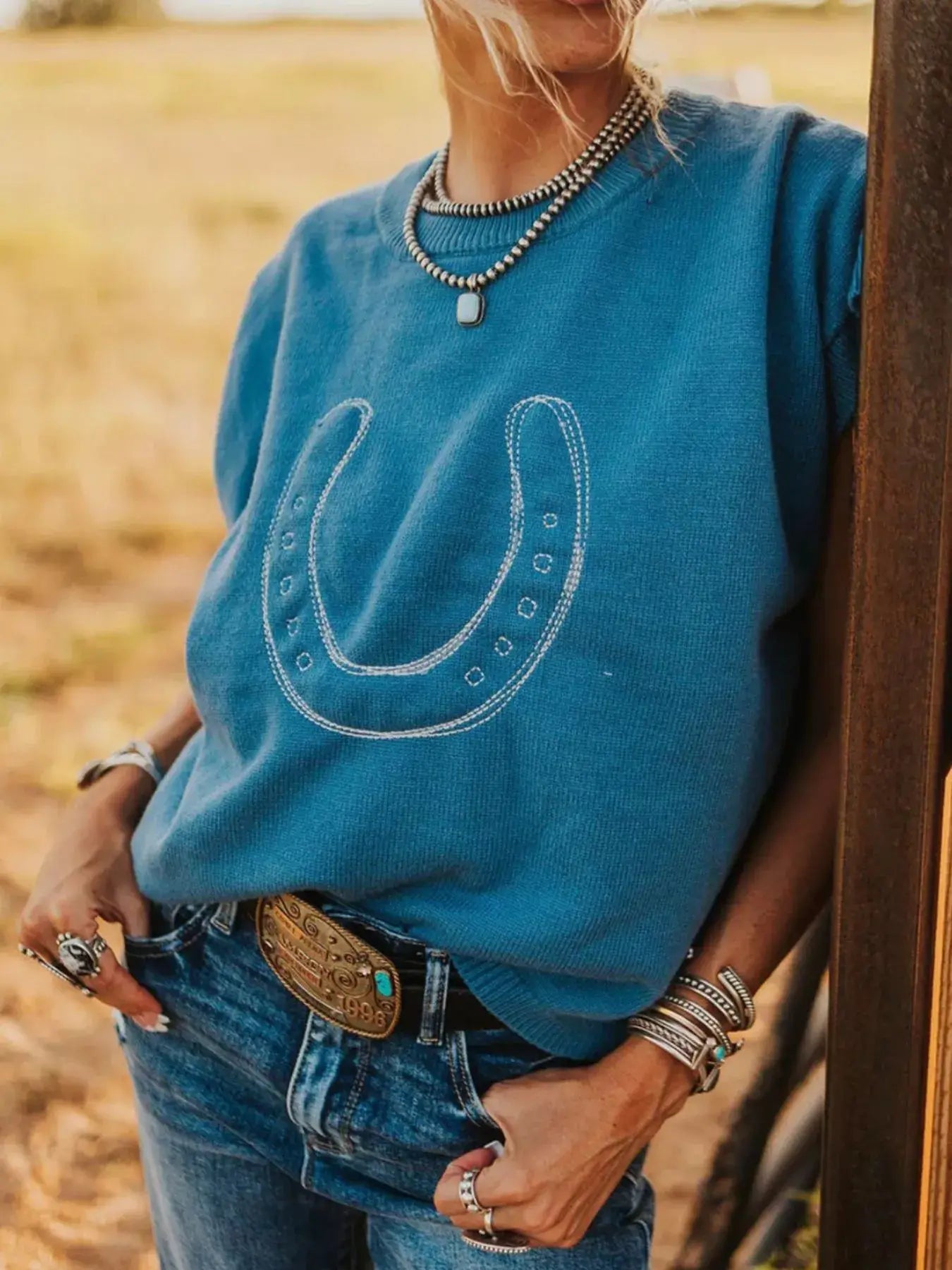 Horseshoe Graphic Round Neck Short Sleeve Top worn by a woman in a casual outdoor setting.