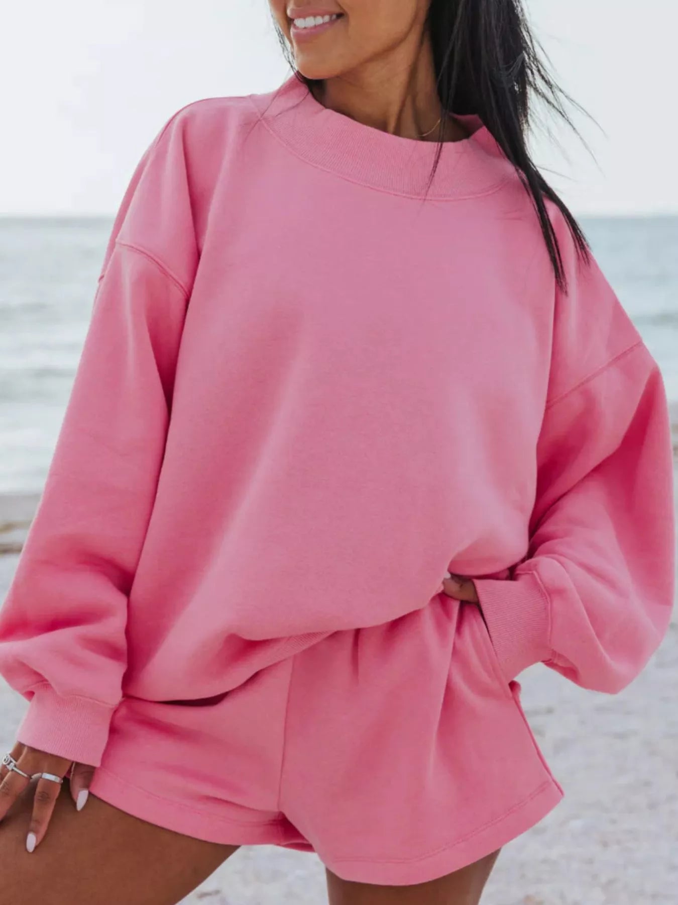 Relaxed Fit Round Neck Sweatshirt and Shorts Set in pink color worn by a woman at the beach.
