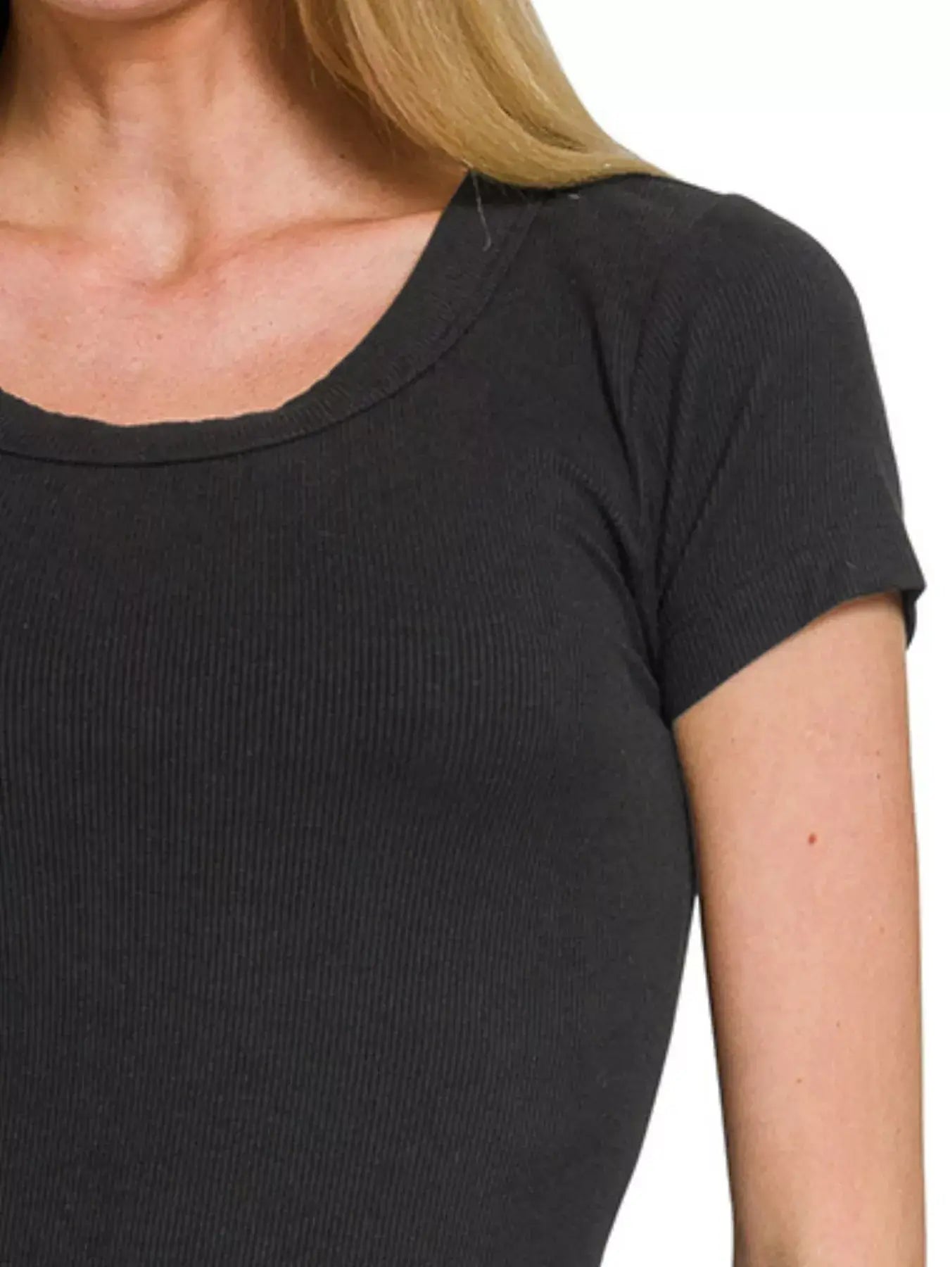 Close-up view of a woman's ribbed round neck short sleeve t-shirt in dark color, highlighting texture and fit.