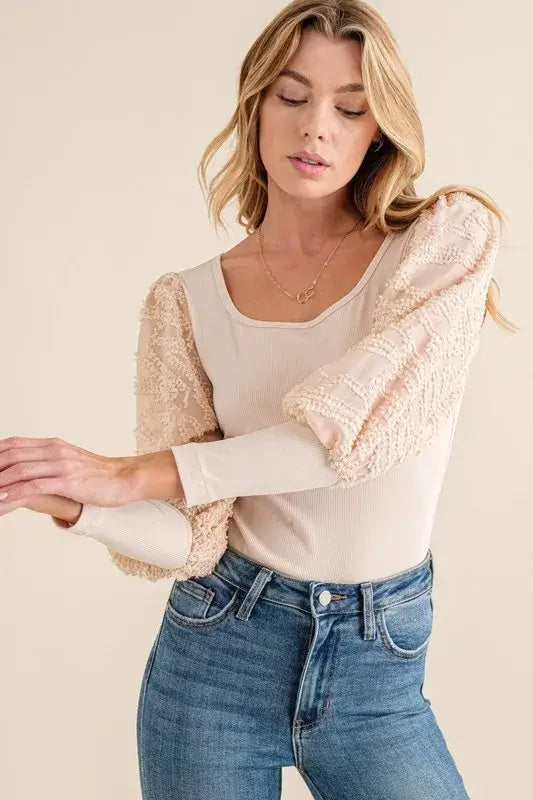Textured puff sleeve bodysuit featuring elegant lace detail, styled with denim jeans for a chic outfit.