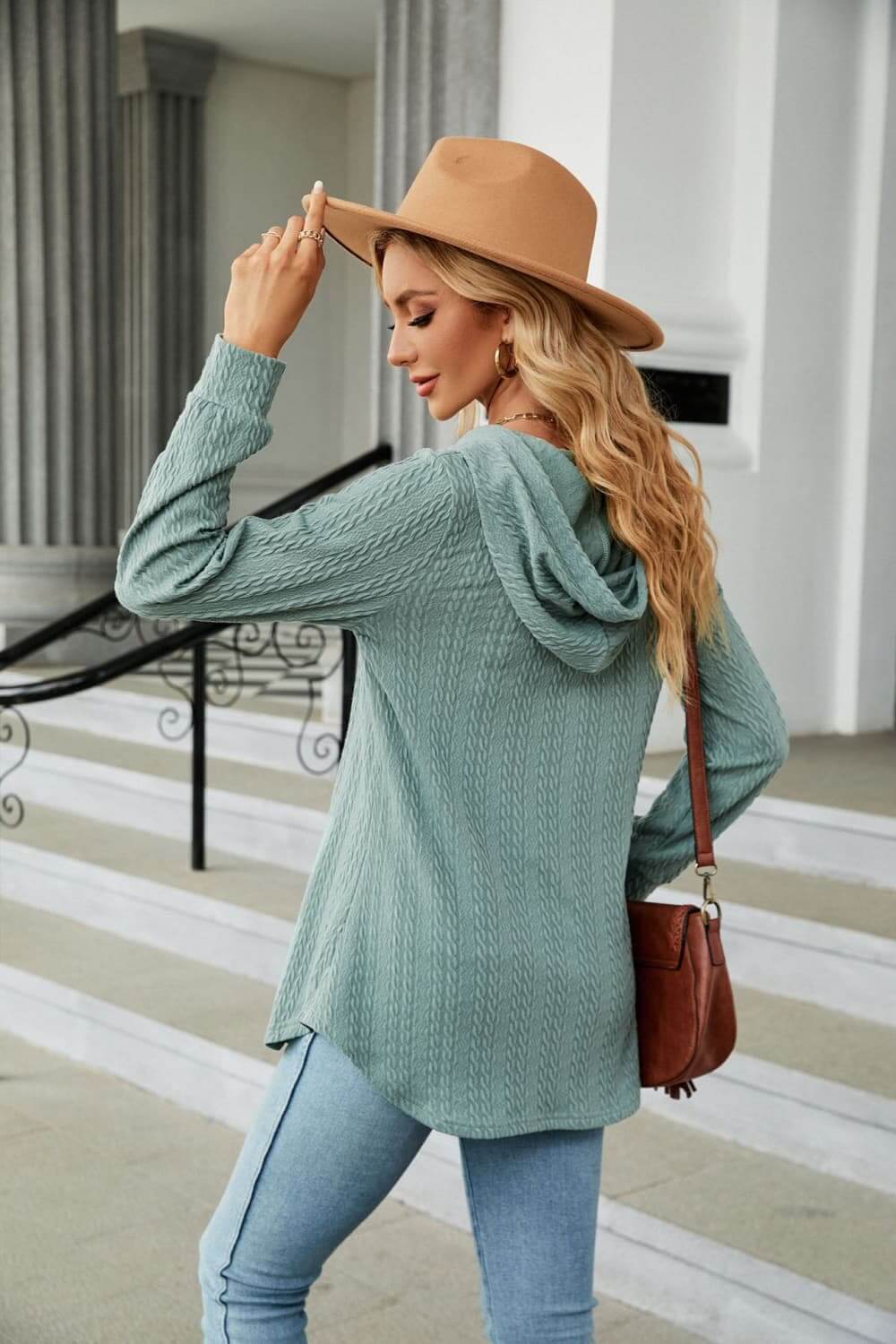 Long Sleeve Hooded Blouse in teal on a model, styled with a hat and denim, showcasing casual and cozy style.