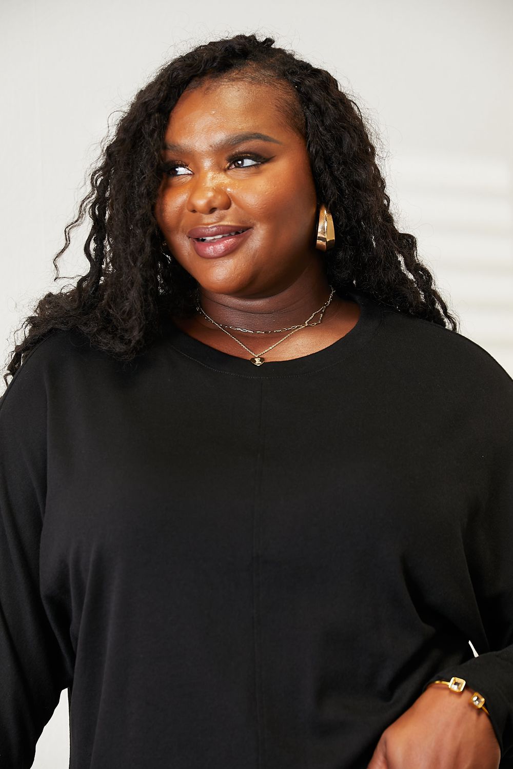 Double Take Seam Detail Round Neck Long Sleeve Top for Women, model showcasing the black top with a stylish design.