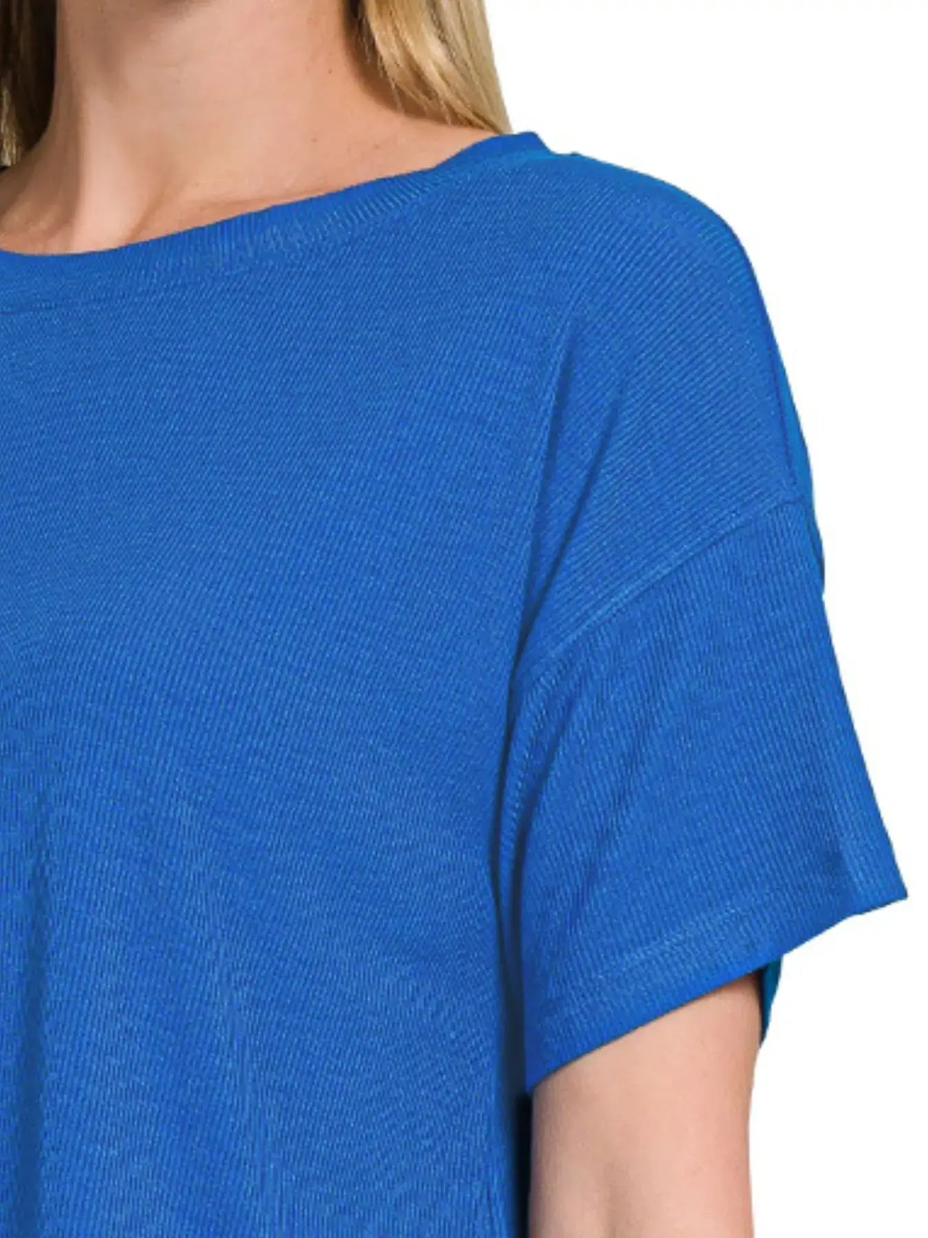 Close-up of a woman's blue ribbed crop t-shirt with a round neck, showcasing its soft texture and oversized style.