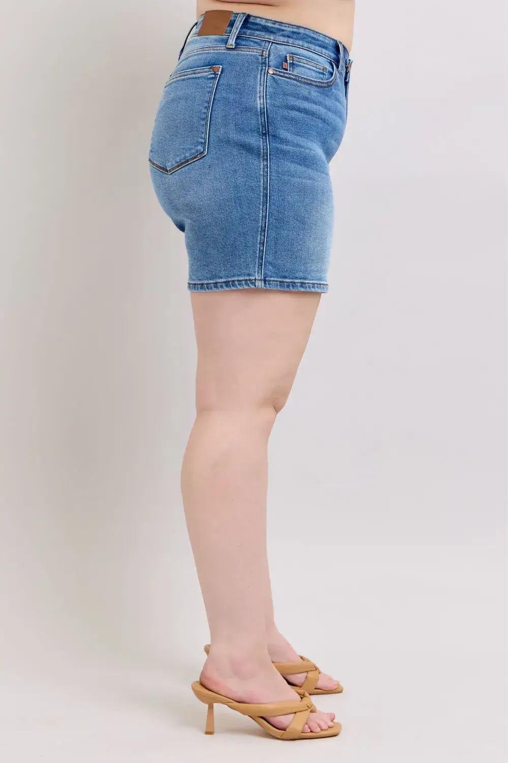Side view of Judy Blue Plus Size Denim Shorts, showcasing 2-button design and pockets.