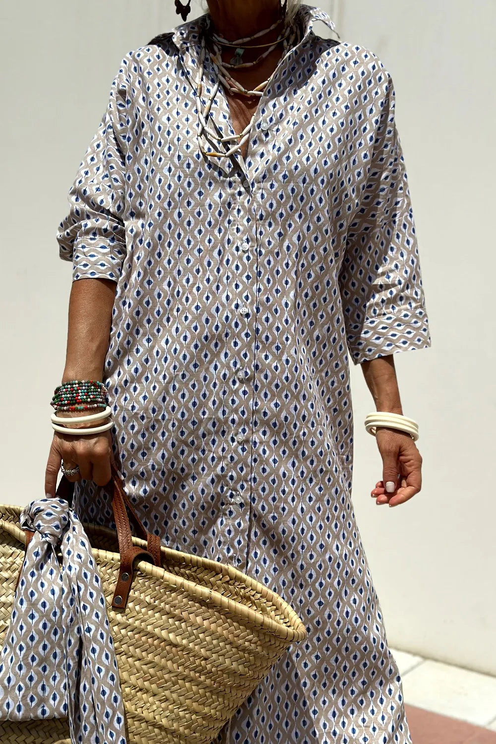 Tied Button Up Three-Quarter Sleeve Dress for Women, featuring a buttoned design and pattern, paired with a straw bag.