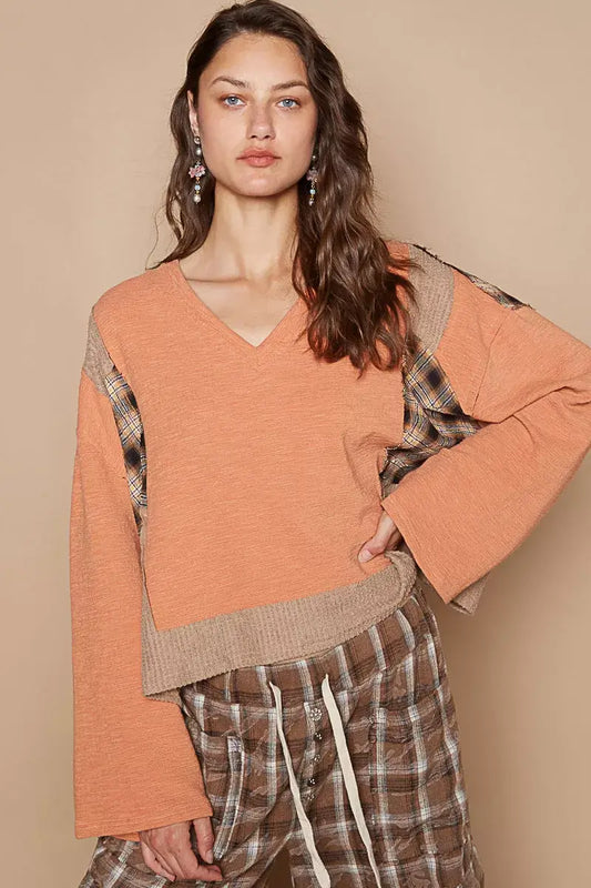 Model wearing POL V-Neck Long Sleeve Plaid Contrast Top with Texture Knit Detail, showcasing an orange and plaid design.
