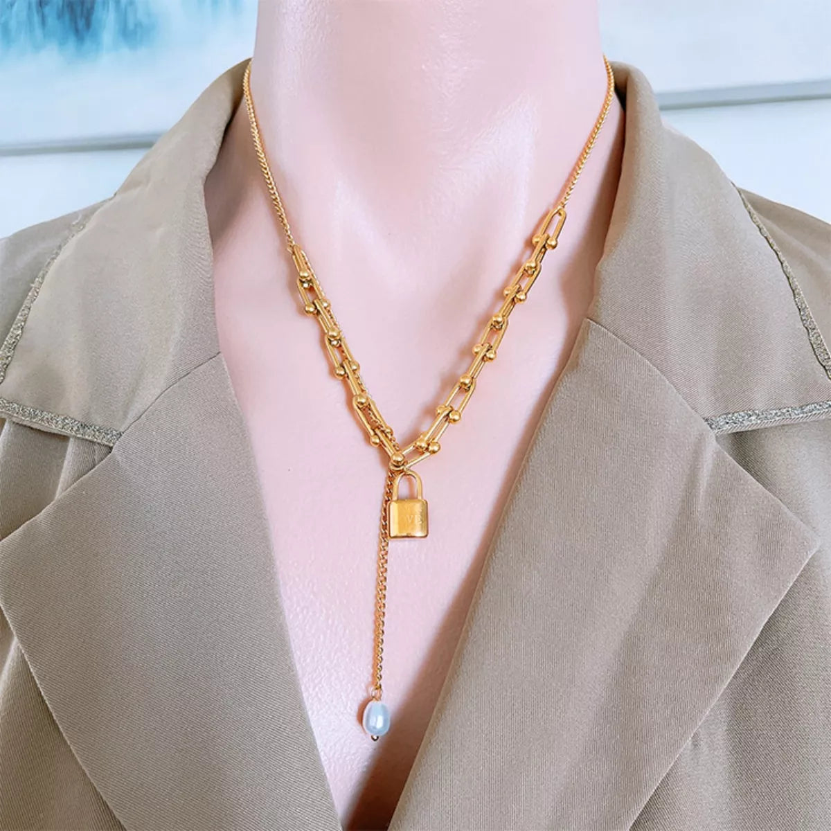 18K Gold-Plated Lock Pendant Necklace worn on a mannequin with a stylish blazer.