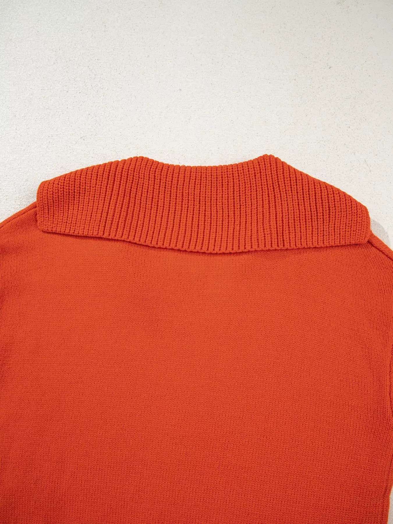 Back view of a collared v neck ribbed edge sweater in vibrant orange, showcasing the ribbed collar design.