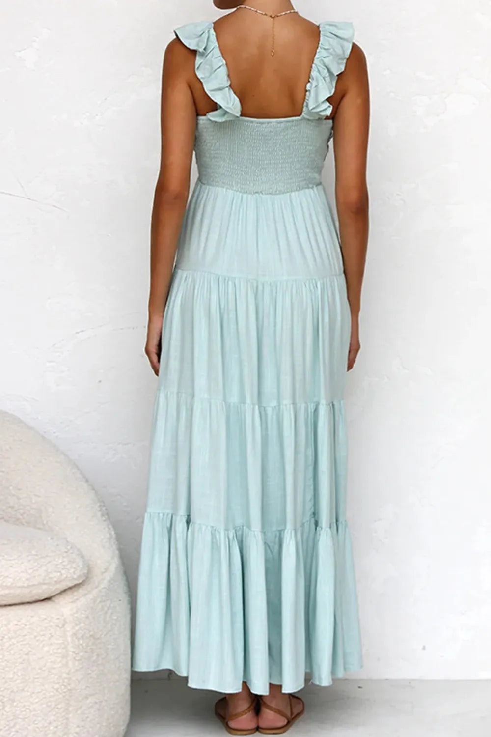 Back view of Ruffled V-Neck Tiered Dress in mint green, showcasing smocked bodice and tiered skirt.