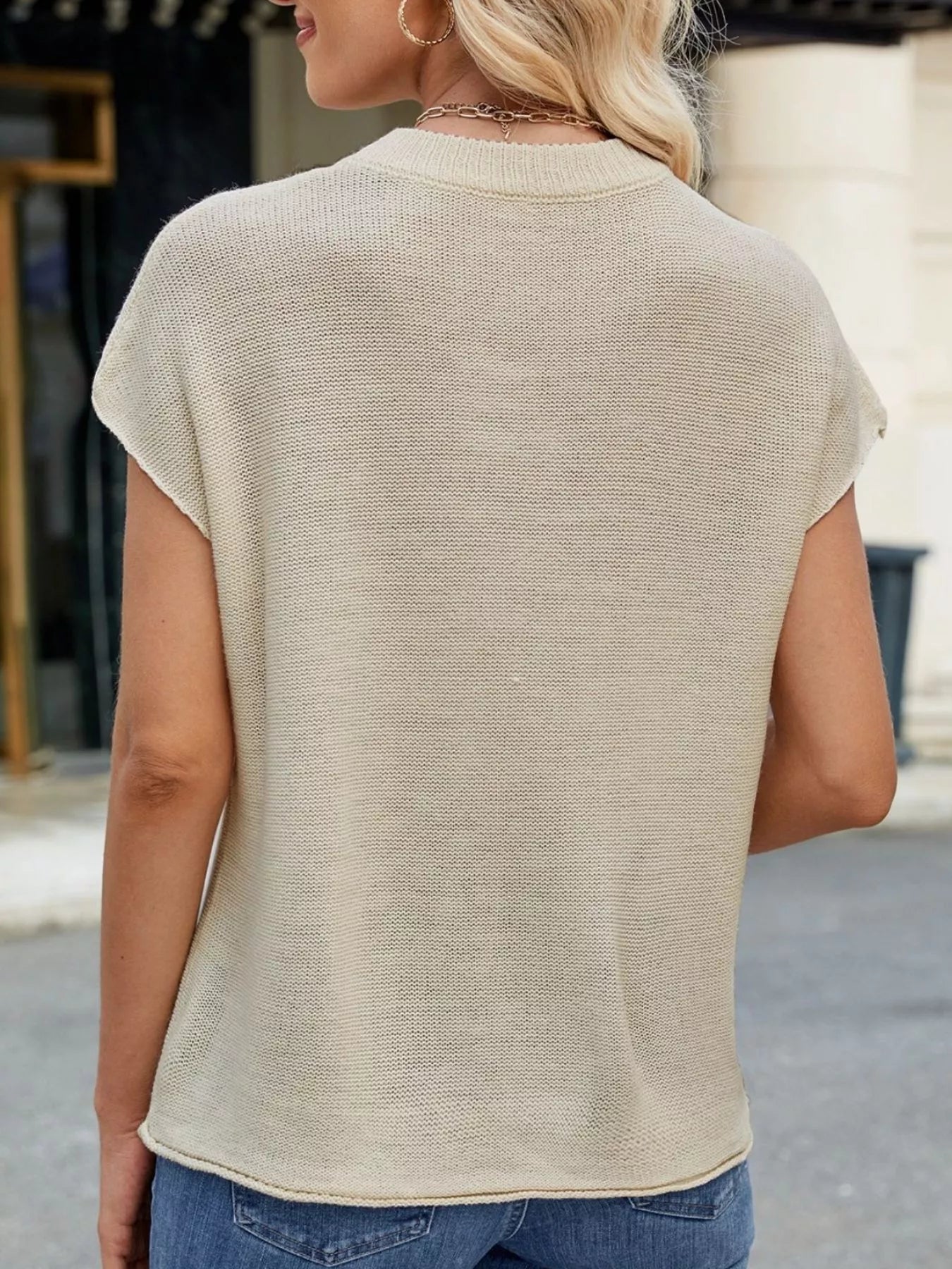Woman wearing a Round Neck Short Sleeve Knit Top with Center Seam Detail, showing back view in a light beige color.