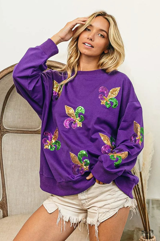 BiBi Fleur De Lis Sequin Patches Mardi Gras Sweatshirt worn by a model, showcasing colorful sequin patches on a purple background.