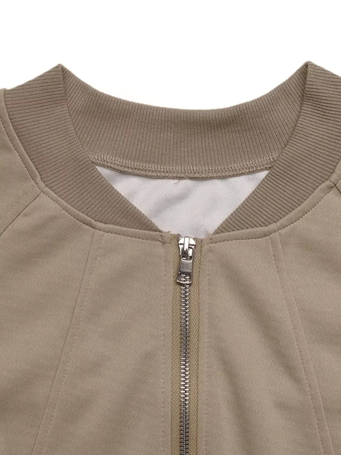 Close-up of the neckline and zipper detail of the Zip Up Raglan Sleeve Jacket in beige.